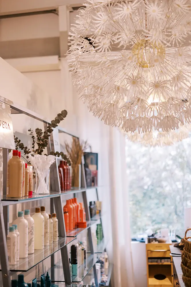 A shelf with bottles and bottles on it. - Chevalrie Salon and Spa