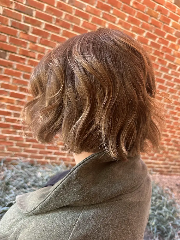 A woman's head with a scarf around her neck. - Chevalrie Salon and Spa